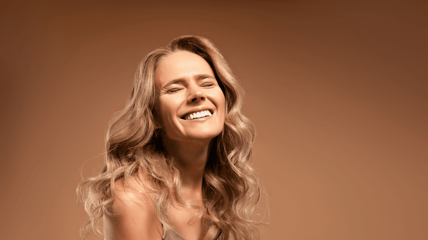 Smiling blonde woman with radiant skin and styled waves, reflecting confidence and elegance — expert hair and skin care results at The Vintage Avenue in Biggleswade.