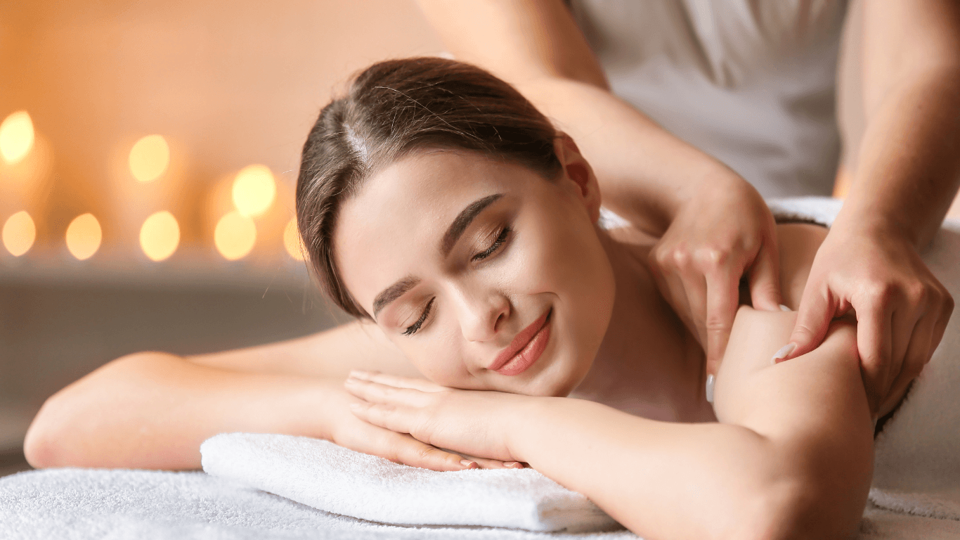 Woman receiving a personalised back and shoulder massage in a serene candlelit setting — capturing the calm and expert care offered at The Vintage Avenue, Biggleswade.