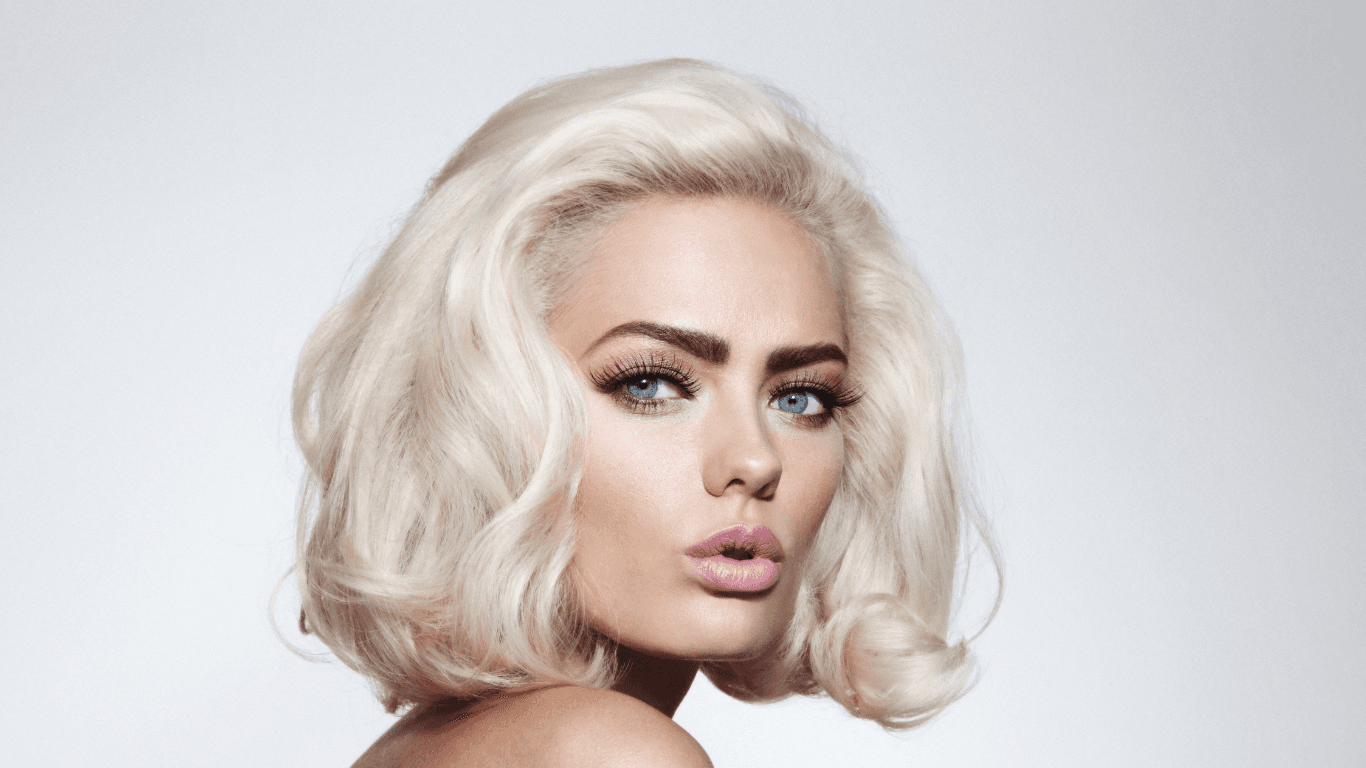 Striking woman with platinum blonde hair and flawless makeup — showcasing expert colour and styling results at The Vintage Avenue salon in Biggleswade, Bedfordshire.