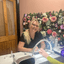Katie, nail technician at Vintage Avenue, smiling while performing a manicure treatment