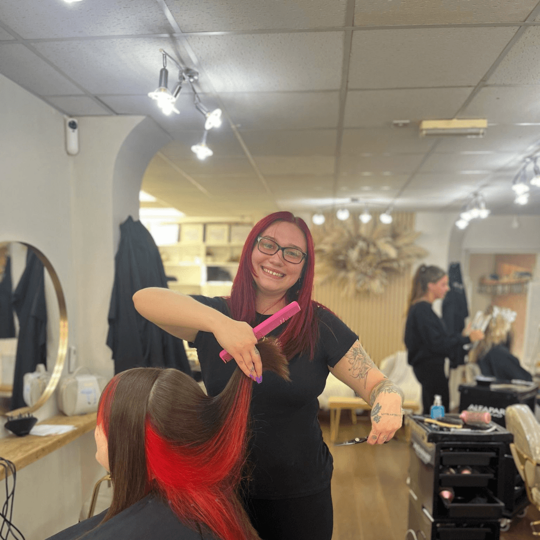 Syd, creative stylist at Vintage Avenue, styling vibrant red hair for a salon client